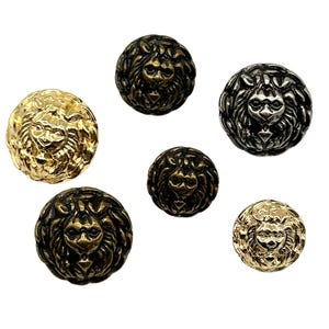 May include: Six lion head buttons in different sizes and finishes. The buttons are gold, silver, and bronze. The lion heads are detailed and have a textured surface.