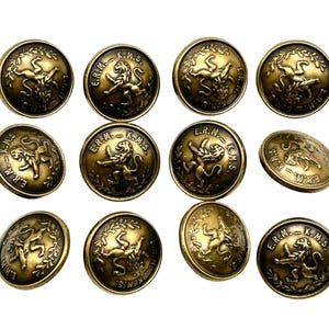 May include: Twelve gold-toned buttons featuring a lion design and the inscription "E.R.M. - K.M.S."