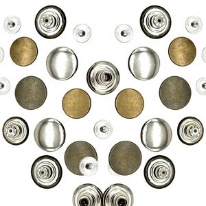 May include: A collection of silver and bronze snap buttons, including both the top and bottom pieces. The buttons are arranged in a heart shape on a white background.