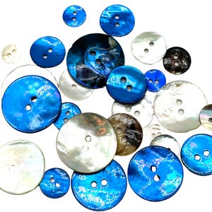 Könnte beinhalten: Sortiment aus blauen, weißen und braunen Muschelknäpfen. Die Knöpfe sind in verschiedenen Größen und haben zwei oder vier Löcher.