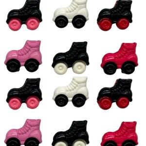 May include: Twelve plastic roller skate buttons in three colors: black, white, and pink. Each button has four wheels and a black or white lace-up design.