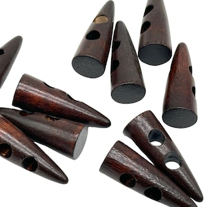 Peut inclure: Un groupe de boutons en bois brun avec deux trous chacun. Les boutons sont en forme de cône pointu et ont une finition lisse et polie.