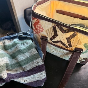 May include: A patchwork tote bag with brown straps and a zipper closure, next to a knitted bag with blue trim and green, white, and purple stripes. The tote features a star design.