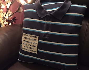 May include: A blue and white striped pillow with a white patch sewn on the front. The patch has the text "THIS IS A T-SHIRT I USED TO WEAR WHENEVER YOU HOLD IT KNOW I AM THERE LOVE GRANDAD JIM" on it.