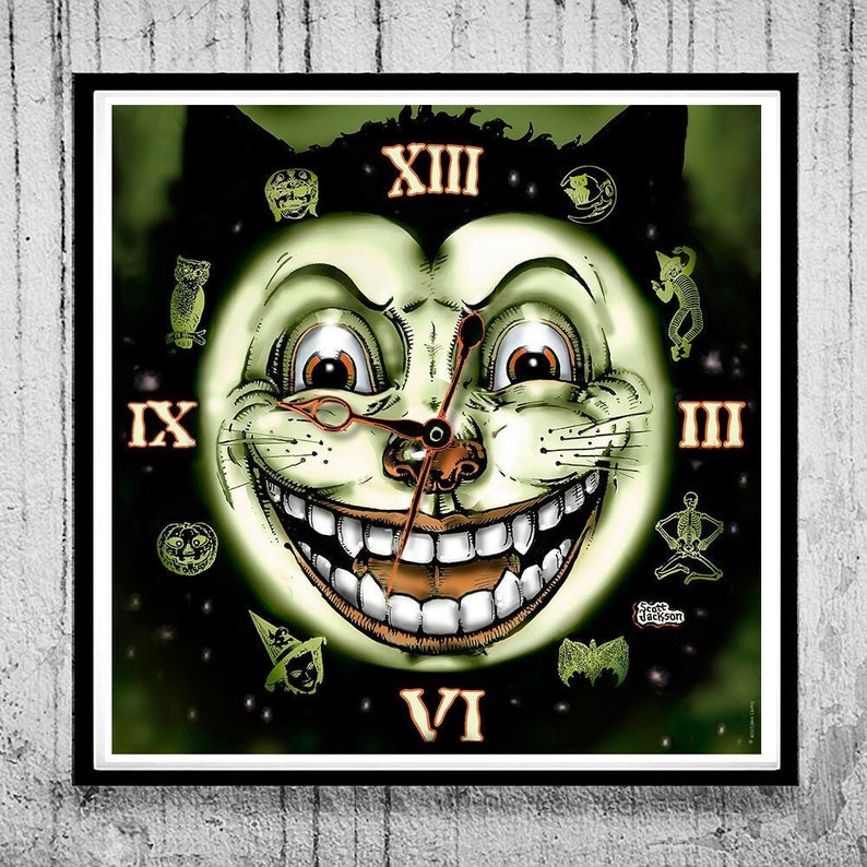 May include: A square wall clock featuring a central illustration of a grinning cat face with large eyes and teeth. The clock face displays Roman numerals XIII, III, VI, and IX, surrounded by small icons of owls, skeletons, and witches in green.