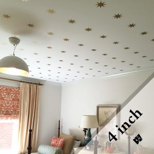 May include: A white ceiling with gold star stickers, a white light fixture, and a bedroom with a bed, curtains, and a lamp. The text "4 inch" is visible in the image.