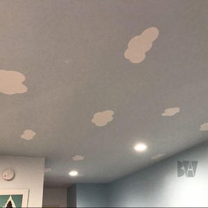 May include: A light blue ceiling with white cloud cutouts. The ceiling has recessed lighting.