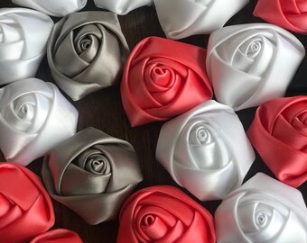 May include: Assortment of handmade fabric rose embellishments in white, gray, black, and coral.