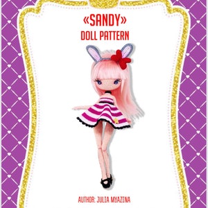 May include: Crochet doll pattern for a pink and white striped dress with bunny ears and a flower. The doll is named "Sandy" and the pattern is by Julia Myazina. The pattern is available on Instagram.