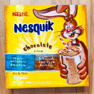 Puede incluir: Una obra de arte pintada a mano de una caja de Nesquik con sabor a chocolate. La caja amarilla presenta el nombre de la marca en azul, un conejo de dibujos animados y una bebida de chocolate. La caja también indica "Vitaminas y minerales esenciales".