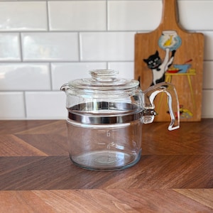 May include: A set of three ceramic mugs with a speckled, matte finish. The mugs are in shades of cream, light gray, and dark gray. Each mug has a simple, minimalist design and a rounded handle.