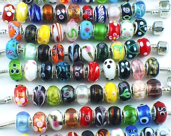 Könnte beinhalten: Eine Sammlung bunter Glasperlen mit verschiedenen Mustern und Designs. Die Perlen sind auf silbernen Ketten aufgefädelt und eignen sich perfekt für die Herstellung von Armbändern oder Halsketten.