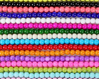 May include: A collection of colorful round beads in various shades of purple, yellow, black, pink, blue, white, green, turquoise, red, orange, lavender, light pink, light green, light blue, pink, and maroon.