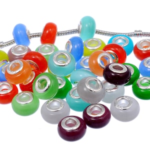 May include: A collection of colorful glow-in-the-dark glass beads with silver metal accents. The beads are round and have a hole in the center for threading onto a bracelet or necklace.