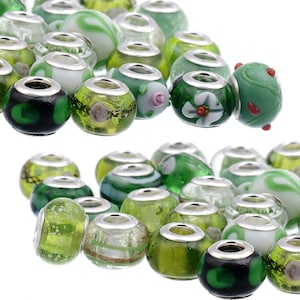 May include: A collection of green glass beads with silver accents. The beads have various patterns, including swirls, dots, and floral designs.