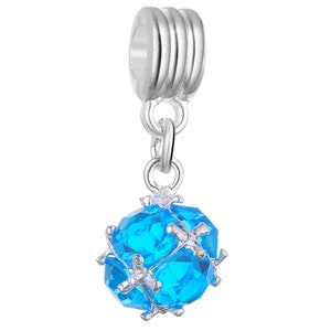 May include: A silver charm featuring a blue crystal ball. The ball is faceted and has a silver frame. The charm has a silver loop for attaching to a bracelet or necklace.