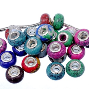 May include: A collection of colorful, round, stone beads with silver accents. The beads have a marbled pattern and are designed for use in jewelry making.