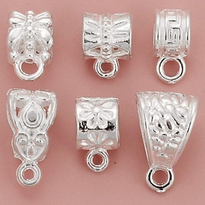 May include: Six silver-toned metal pendant clasps with various decorative designs. The clasps have a loop at the bottom for attaching to a necklace or bracelet.