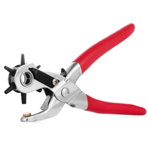 May include: A red-handled metal punch tool with a star-shaped punch head. The tool is used for creating holes in leather, paper, or other materials.