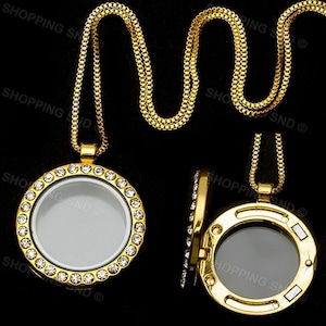 May include: A gold chain necklace with a round locket pendant. The locket is decorated with clear rhinestones and has a clear glass insert. The locket is open to reveal the inside.