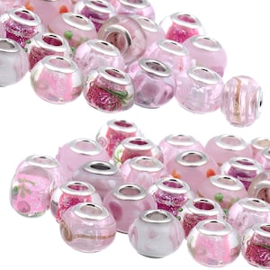 May include: A collection of pink glass beads with silver accents. The beads have a variety of designs, including flowers, glitter, and swirls.