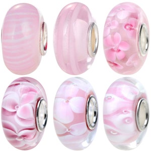 May include: Six pink glass beads with silver accents. The beads have different patterns, including stripes, flowers, and swirls.
