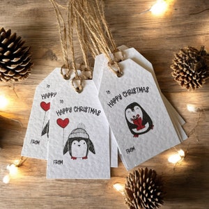 May include: Set of four white gift tags with black and red penguin illustrations. The tags say "To Happy Christmas" and "From".