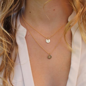 Peut inclure: Deux colliers en or avec des pendentifs initiaux. Le collier du haut a un pendentif plus grand avec la lettre "S" et le collier du bas a un pendentif plus petit avec la lettre "C".