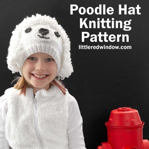 May include: A child wearing a white knitted poodle hat with black eyes and nose, a white fluffy jacket, and white trousers. The child is holding a yellow tennis ball. The background is a black wall with a red fire hydrant.