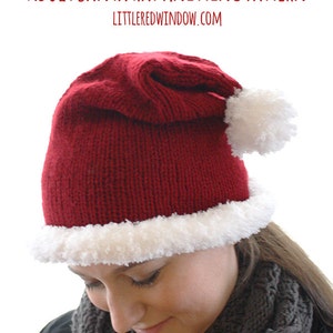 May include: A red knitted Santa hat with a white pom-pom and a white fur trim. The hat is worn by a person with brown hair and a grey scarf. The text "ADULT SANTA HAT KNITTING PATTERN" and "LITTLE REDWINDOW.COM" is visible at the top of the image.