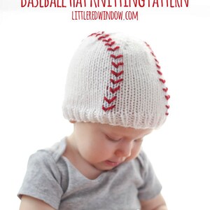 May include: A white knitted baseball hat with red stitching. A baby is wearing the hat and holding a baseball.