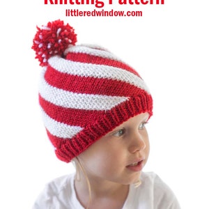 May include: A child wearing a red and white striped knit hat with a white pom pom on top. The hat has a peppermint twist design. The text "Peppermint Twist Hat Knitting Pattern littleredwindow.com" is above the child's head.