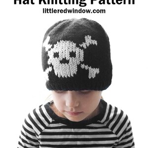 May include: A child wearing a black and white striped shirt and a black knit hat with a white skull and crossbones design. The hat is from the pattern available at littleredwindow.com.