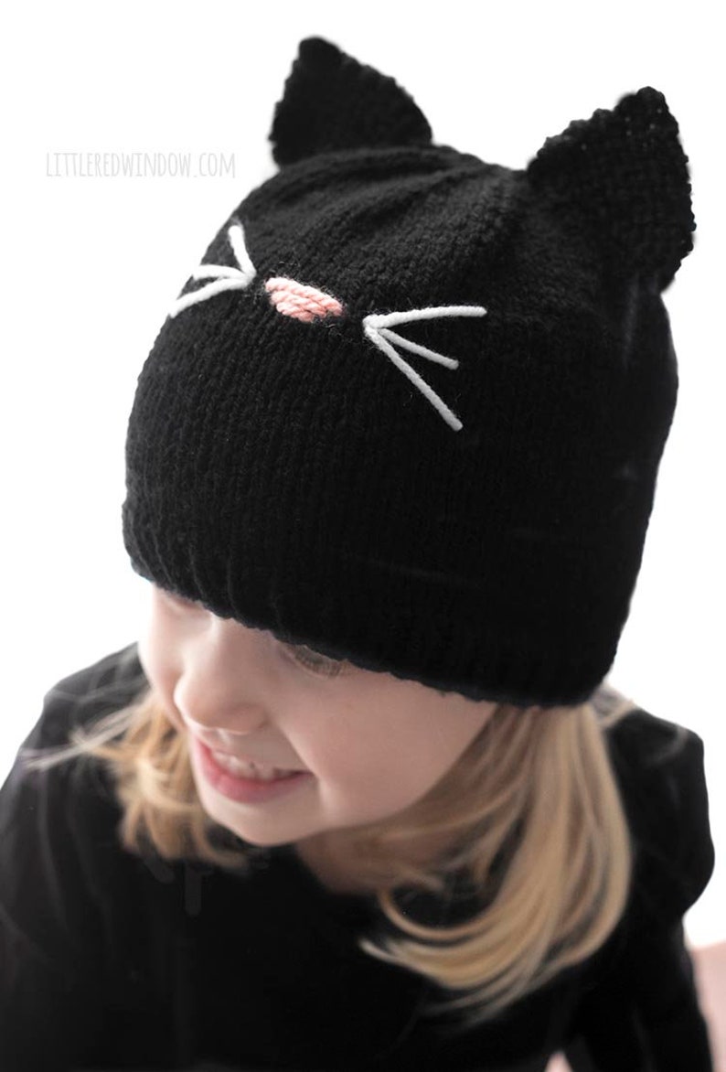 Little girl wearing black knit cat hat and looking off to the near left