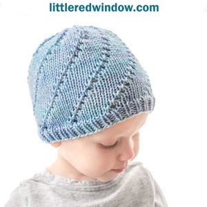 May include: A blue and purple knitted hat with a lace twist pattern. The hat is on a child's head. The text "Lace Twist Hat Knitting Pattern littleredwindow.com" is above the image.