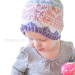 baby wearing knit easter egg hat and holding one pink easter egg