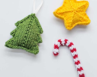 Puede incluir: Un conjunto de tres adornos de árbol de Navidad tejidos: un árbol de Navidad verde, una estrella amarilla y un bastón de caramelo rojo y blanco. Los adornos están hechos a mano y tienen un diseño simple y clásico.
