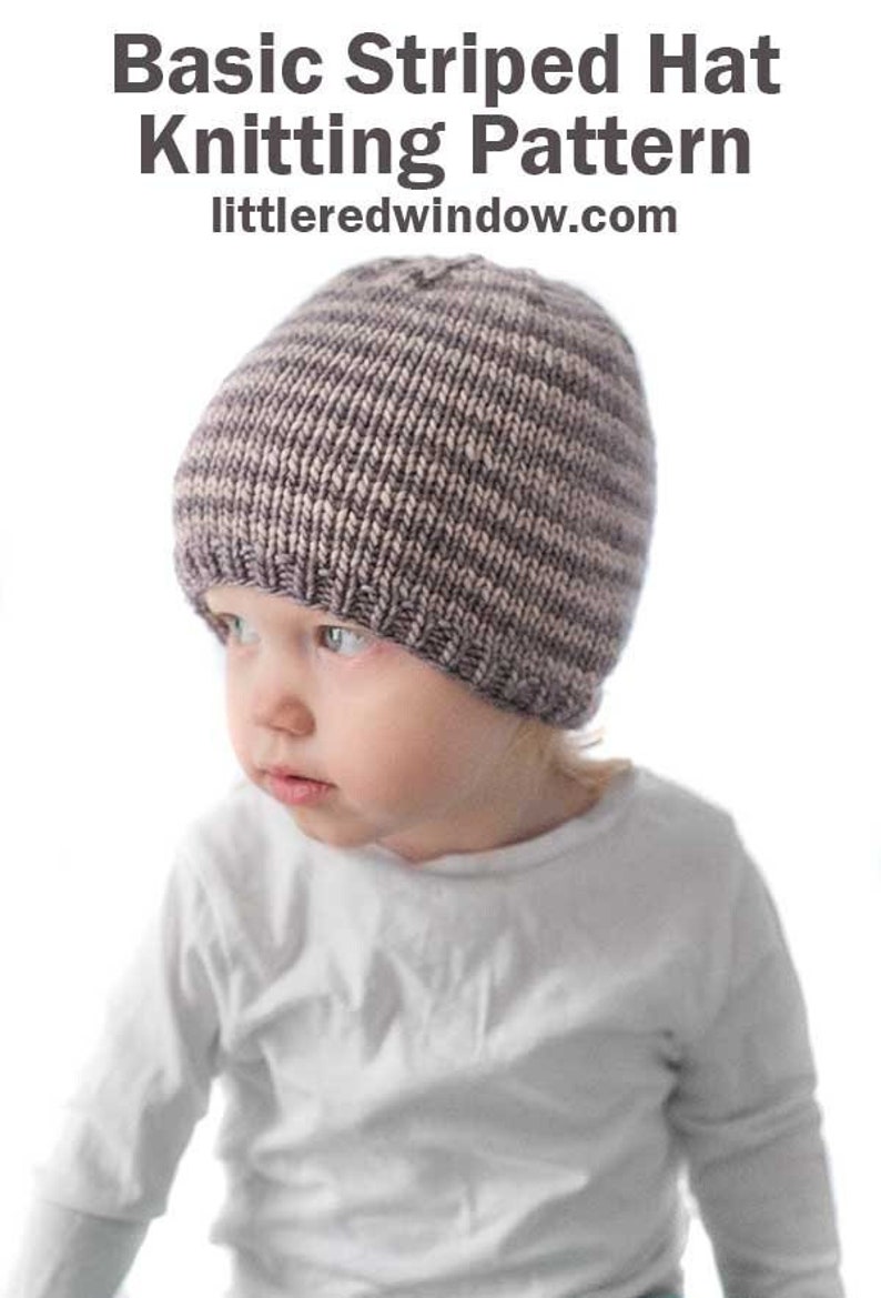 toddler in white shirt wearing a tan and medium brown thin striped knit hat looking to the left in front of a white background