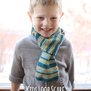 May include: A young boy wearing a gray sweater and a striped blue, green, and yellow knitted loop scarf. The scarf is tied in a loop around his neck. The text "Kids Loop Scarf Knitting Pattern" and "littleredwindow.com" is below the boy.