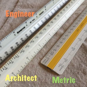 May include: Two white rulers labeled "Engineer" and "Staedtler 987 18-34" and a yellow ruler labeled "Pickett 335" with the words "Architect" and "Metric" written below.