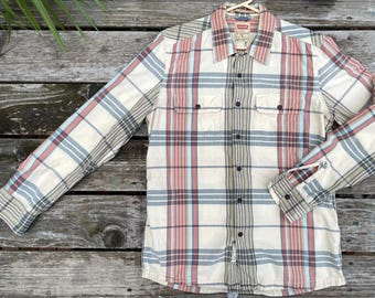 May include: A long-sleeved plaid shirt with a button-down collar and two chest pockets. The shirt is in a cream, red, and blue plaid pattern.