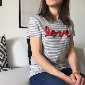 Camiseta listrada com gola redonda e escrita LOVE