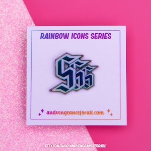 May include: A rainbow iridescent enamel pin featuring the letter "S" in a stylized gothic font. The pin is on a white card with the text "RAINBOW ICONS SERIES" and "andvengeanceforall.com".