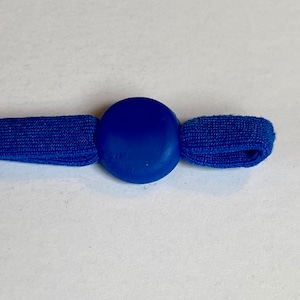 May include: A blue elastic cord with a round blue plastic toggle. The toggle is smooth and has a slight shine.