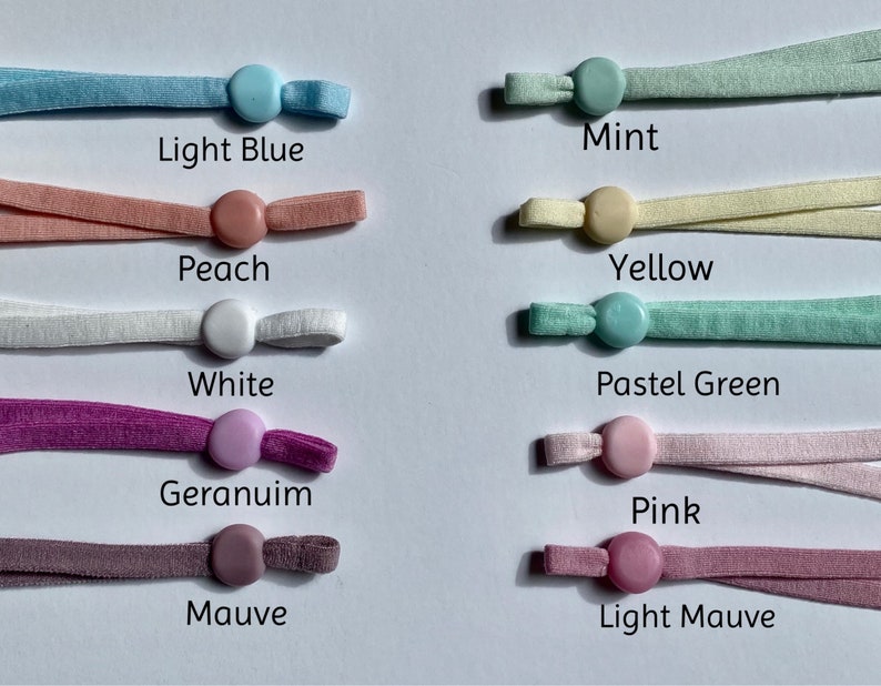 May include: Assortment of 10 colors of elastic cord with plastic stoppers. Colors include light blue, peach, white, geranium, mauve, mint, yellow, pastel green, pink, and light mauve.