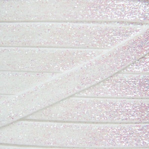 Può includere: Nastro bianco con glitter iridescente con un leggero bagliore. Il nastro è piegato in diagonale, mostrando lo scintillio del glitter.