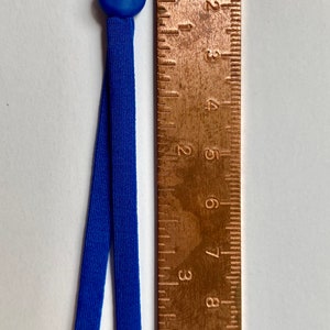 May include: A pair of blue elastic mask extenders with a blue plastic adjuster. The extenders are about 8 inches long and are measured against a ruler.