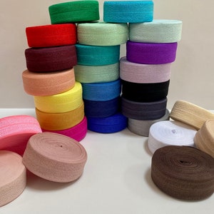 Puede incluir: Una colecci&oacute;n de bandas el&aacute;sticas coloridas en varios tonos, incluyendo rosa, rojo, verde, azul y morado. Algunas est&aacute;n apiladas, otras enrolladas. Las bandas son de tela texturizada.