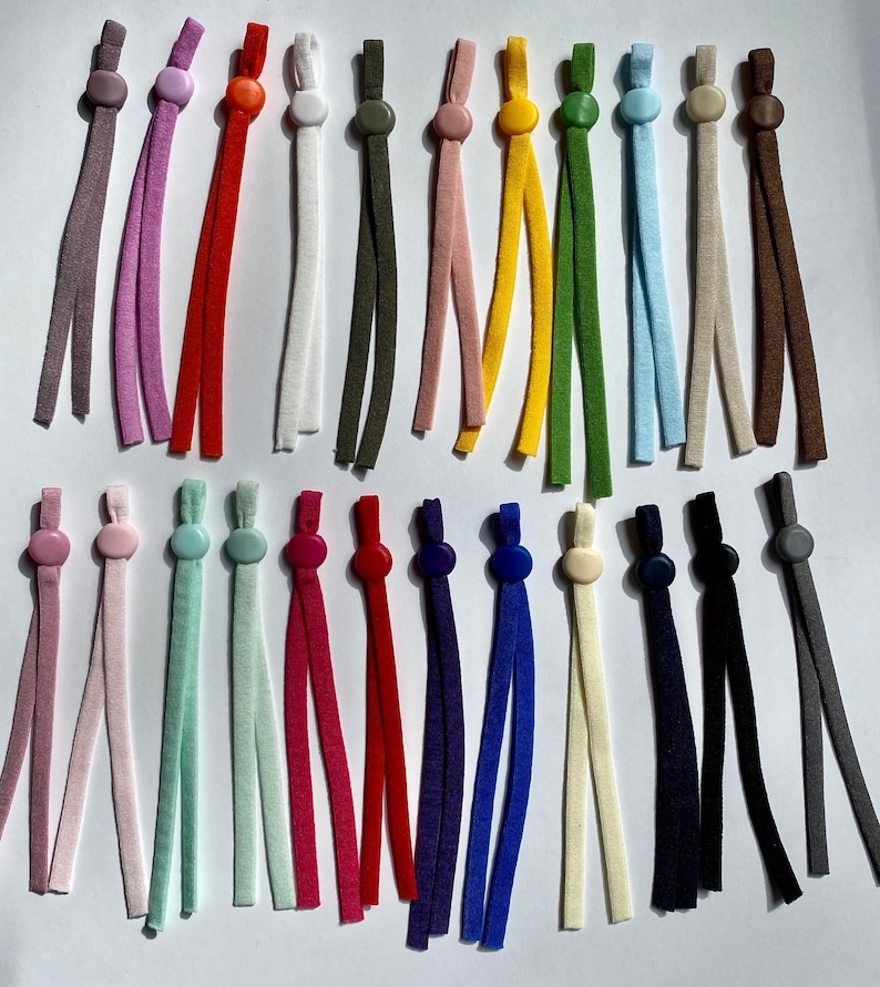 May include: Assortment of 20 colorful elastic cords with plastic stoppers. The cords are in various colors, including purple, pink, red, white, green, yellow, blue, brown, and gray. The stoppers are in matching colors.