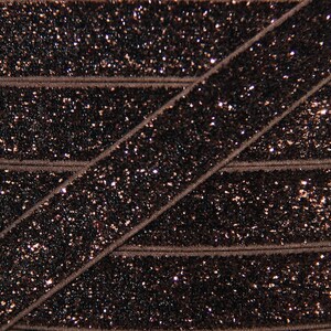 May include: Brown elastic ribbon with a sparkly finish. The ribbon is made of a soft, stretchy material and is perfect for adding a touch of sparkle to any project.